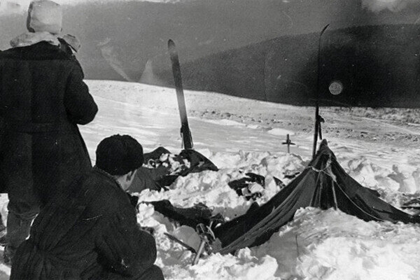 Частично раскопанная от снега палатка группы Дятлова. Слева от палатки поисковики Владислав Карелин (стоит) и Юрий Коптелов. / Фото участника поисков А. С. Чеглакова