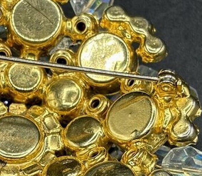 Обратная сторона броши , предположительно Д и Е .