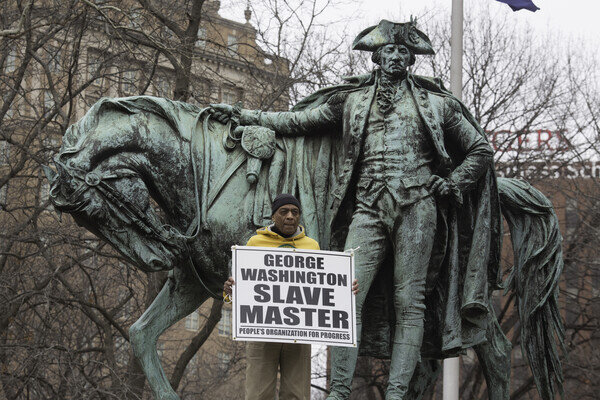 Активист Ларри Хэмм у статуи Джорджа Вашингтона в Вашингтонском парке с табличкой «Джордж Вашингтон — рабовладелец», 2018 год / Brian Branch Price/Global Look Press