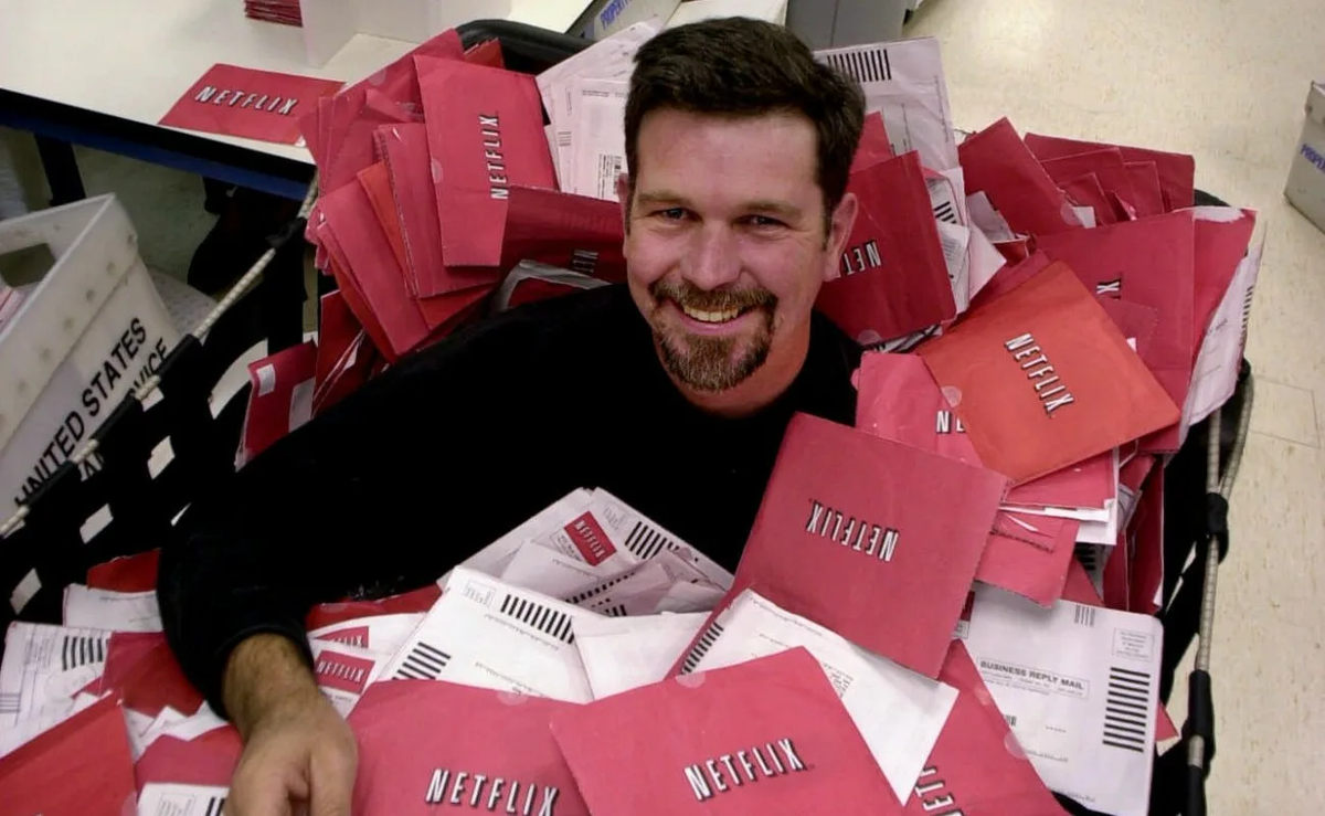 Генеральный директор Netflix Рид Хастингс в тележке, полной DVD-дисков, готовых к отправке