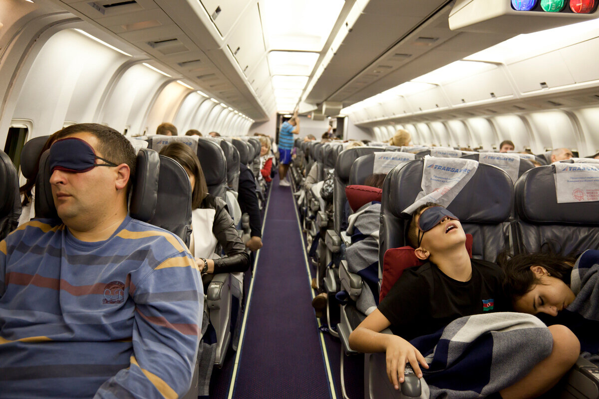 Люди сидят в самолете. Самолет с пассажиром. Люди в самолете. Салон самолета. Салон самолета с пассажирами.