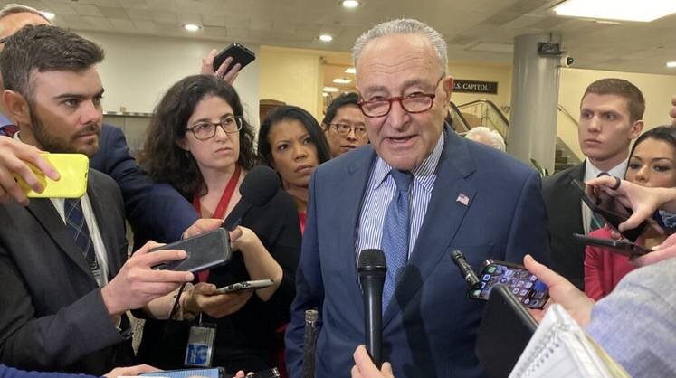    Jennifer Shutt/States Newsroom Лидер демократического большинства Чак Шумер (в центре) объясняет журналистам, почему проголосовал против законопроекта, в который входил пакет помощи Украине