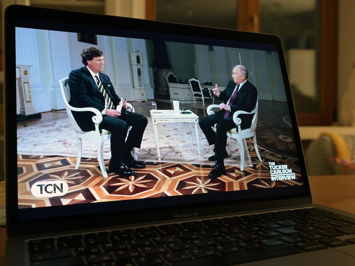    Трансляция интервью президента РФ Владимира Путина американскому журналисту Такеру Карлсону на экране компьютера© РИА Новости / Александр Кряжев