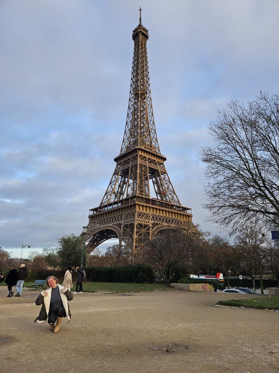 
Сегодня 31 декабря. Канун Нового года. И именно на сегодня запланирован наш подъем на самое высокое сооружение в Париже. Билеты мы покупали заранее онлайн. Наш тариф включал в себя подъем на лифте на верхнюю площадку и бокал шампанского. Звучит очень романтично, не правда ли?
Моросящий дождь сегодня решил взять выходной. Его сменил сдувающий с ног ветер. Прям идеальная погода для подъема на большую высоту. Удача идет за нами по пятам.
Чтобы добраться до башни нам нужно было сначала проехать 10 минут на трамвае, 30 минут на метро, потом 15 минут подождать поезд и вот через 10 минут мы уже смотрим на самую фотографируемую достопримечательность в мире. На входе, как и везде, большая очередь. Сумки просвечивают через сканер. Проходим контроль и попадаем на территорию. Еще одна очередь уже ко входу на саму башню. Вернее, одна на покупку билетов, вторая на вход. Так как билеты куплены заранее, становимся сразу на вход. А бедолаги, не подготовившиеся как мы, терпеливо стоят обе. Примерно через полчаса мы проходим очередь и снова проверка сумок и карманов. После еще одна очередь. Уже к лифту. В итоге, примерно через час мы окончательно проходим все проверки, и лифт взмывает вверх. Факт 6. Билеты на все достопримечательности лучше покупать заранее.
Пока лифт несет нас вверх, любуемся видами Парижа. Немного жутковато, конечно, от такой высоты, но красиво. И вот мы, наконец наверху на высоте 276 метров. Вид на город отсюда, действительно, потрясающий. Вот только площадка обнесена решеткой. Чтобы полюбоваться Парижем без металлических преград, поднимается на один уровень выше. Вот теперь да. Супер! Весь город как на ладони. Но как только я достаю телефон, чтобы сделать фото, как налетает сильный порыв ветра. Я с трудом удержала телефон в руках и спустилась на безопасное расстояние. Что ж, пусть мои фото будут в клеточку, но этот невероятный вид с высоты, я сохранила в памяти навсегда.
И так, вспоминаю, что по билету нам положены 2 бокала шампанского.
-Я уже ничего не хочу, - недовольно ворчит Йоханн. – Здесь слишком много люди. Я не знаю, где брать шампанского. Поехали обратно.
В смысле? Как это так? Да, я 2 недели репетировала этот кадр с шампанским на Эйфелевой башне. Как Ди Каприо в «Великом Гэтсби». И ты мне сейчас говоришь, что шампанского не будет? Нет уж, пошли искать!
На площадке расположен 1 ресторан и 2 бара. Один на улице, другой внутри. И никто из них не хотел наливать нам это пресловутое шампанское. Из ресторана отправили во внутренний бар, из внутреннего в бар на улице, из бара на улице отправили куда-то на французском. Спасла нас женщина из сувенирной лавки, которая с уверенностью отправила нас в бар на улице. Когда мы вернулись к бару во второй раз, бармен вздохнул и налил нам наше заслуженное шампанское. Итак, план выполнен-пора двигаться к выходу. Стоит еще 20 минут в очереди к лифту и покидаем символ Парижа. Проходим по Йенскому мосту, мимо иммигрантов, торгующих миниатюрными башнями, и попадаем на площадь Трокадеро. Если верить нашему путеводителю, то отсюда открывается самый красивый вид на Эйфелеву башню. Путеводитель не врал. Да и вообще место романтическое и очень атмосферное.
После ужина мы возвращаемся в наш апарт-отель встречать новый 2024 год. Признаюсь, хотела встретить бой курантов на фоне Эйфелевой башни, но Йоханн был категорически против.
-Много люди, много иммигрантов, ist dangerous! – как мантру повторял он.
Для приличия я поспорила с ним, но, если быть честной, то после бесконечного стояния в очередях, мне и самой больше не хотелось никуда идти.
Поэтому Новый 2024 год мы встретили вдвоем. С французским шампанским, русской водочкой и под бой кремлевских курантов.  