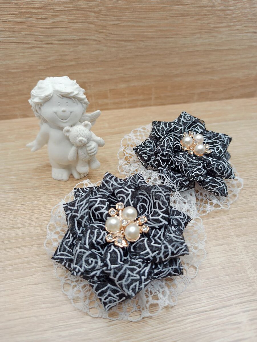 Банты для волос изготовлены из органзы чёрного цвета, ажурной белой ленты и декорированы жемчужными стразами Заказать эти банты можно на WILDBERRIES, артикул 165326876.