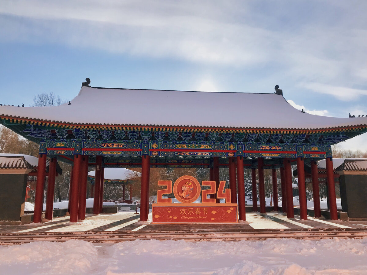 Надпись гласит: "С Праздником Весны!", а на фотографии снега по колено. Московский парк Хуамин. // Из личного архива