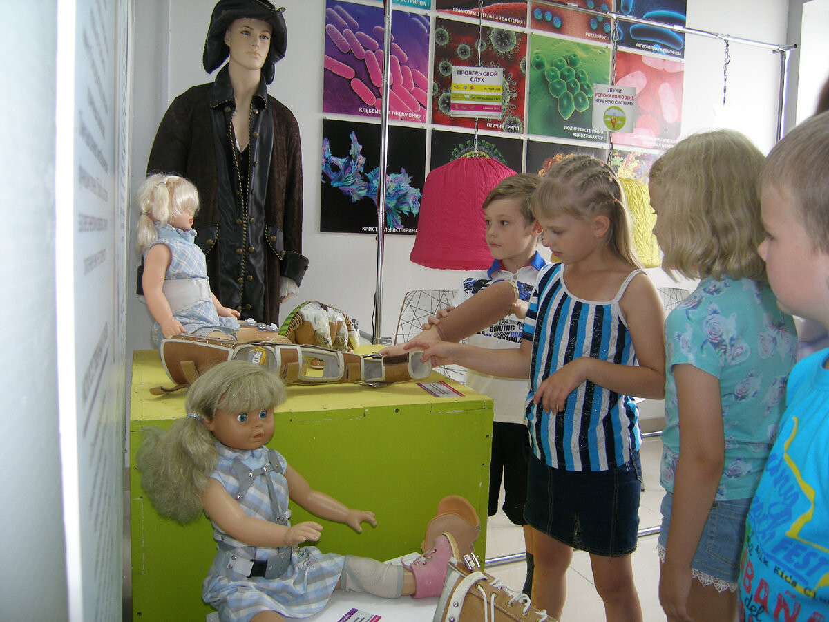 Наша выставка "Медицина" Раздел протезирование. На заднем плане Капитан Крюк, он ведь тоже был с протезом. На куклах различные бандажи. Также в этом разделе демонстрировались тазобедренные и коленные суставы и протез ноги, который мог сгибаться при ходьбе, 3д принтер, печатающий черепные пластины и кости. На заднем фоне экспонат для проверки слуха. 