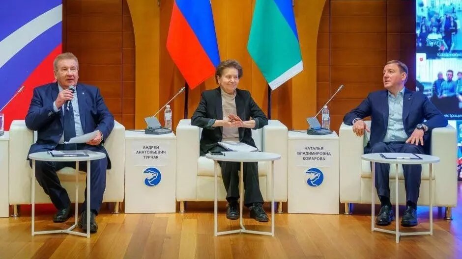 Согласно размещенным табличкам с фамилиями, в центре должен был сидеть Турчак, но там в итоге расположилась Комарова. Фото: BRIEF