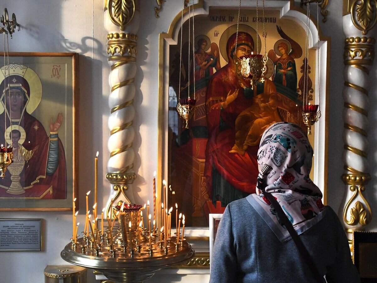    Верующая в храме Успения Божией Матери© РИА Новости / Виталий Аньков