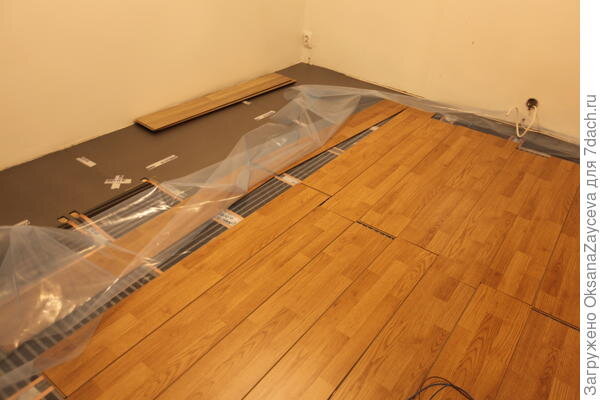 
Пленочный пол, подготовлен для работы электрика

Медные кончики с одной стороны заклеиваются специальными зелеными кружками изолятора. Они тоже идут в наборе. А с другой стороны последовательно соединяются полотна пленки при помощи специальных контактов и проводов. Под контактами изолятор вырезается, кусочки 3 на 4 см больше контактов.


Контакты закусывают медные полоски, с другой стороны к ним крепятся провода

По поводу проводов хочу сказать: провода подходят только от производителя!
Казалось бы на фото они одинаковые, но! Те, что от производителя — многожильные и с двойной изоляцией, магазинные — одножильные и с одинарной изоляцией. А диаметр одинаковый! И цвет тоже =)

Может поэтому у кого-то и не греет пол...


Провода размотанные — от производителя, в мотках из магазина

Нам пол подключают вместо снятой батареи, к тем же проводам. Пол потребляет меньше энергии, чем батарея — электрический конвектор. Так что пол будет явно экономичнее.

Поверх пленки излучающей кладется пленка изоляционная, строительная. У нас ее на гидроизоляцию крыш используют тоже. Толстая пленка, не фирменная, слава богу =)

А вот поверх уже можно класть ламинат толщиной не менее 6 мм!
Паркет 1,5 см подошел бы идеально! Но дети… эх...
У нас 5 мм винил. 5 мм мало. Производитель порекомендовал положить «черновой пол из дерева». Подойдет как фанера, так и дешевый ламинат. То же касается и линолеума и ковролина. Нужен черновой деревянный пол толщиной не менее 6 мм.

Мы взяли дешевый ламинат.


Вот так у нас выложен контур мебели, поверх уже лежит пленка и черновой ламинат. Провод на стене — раньше висела батарея, теперь туда запитают обогрев пола

Итого, пол у нас поднимется ровно на 5 мм винила, потому как остальной пол — старый сантиметровый паркет. В комнате раньше лежал ламинат на доисторическом ковролине...
Как будет греть — узнаем через 2 недели, когда придут электрики и  подключат нашу мозаику к сети =)
Производитель обещает нагрев пола до +40ºC.

А пока мы оценили — простоту укладки (мы все сделали со свекровью =)  пока муж в командировке)!
Провода вот только не подключали и не штрабили =)

Большое количество технических нюансов (как всегда не прописанных в инструкции) предоставляют кучу возможностей ошибиться. Увы, надо пытать производителя по любому поводу. 
Также нужен специальный инструмент для соединения контактов. Его нужно приобрести отдельно.
Ну и подъем пола незначительный абсолютно.

Ну а по ценнику… 500 евро набор на 12 м² (только пленки, 27 м при ширине 43 см; помним, что под мебель нельзя класть). В наборе и термодатчик, и контрольная панель управления, и провода с контактами для подключения. Дешевле это или дороже других полов… не знаю. С работой по расковыриванию пола так точно дешевле!

Вот так легко и без подвига мы станем обладателями теплых полов в квартире и избавимся наконец от конвекторов, украшающих все наши стены (по всему жилью висят 15! конвекторных батарей! Дорого, некрасиво и воняет, когда пыль осенью прогорает) =)

Но это секрет!Купив старое жилье, мы, конечно же, начали нескончаемый ремонт. Интересным решением и опытом был теплый пол под паркет\ламинат\винил.

Чтобы не ковырять отбойником 130 м² и не опускать и без того низкие потолки, мы остановились на инфракрасном пленочном поле. Но, увы, в сети очень много плохих отзывов, мол не работает, не греет достаточно. Мы пошли на этот эксперимент, решив, что сделаем все точно по технологии. Много общались, переписывались с производителем — компанией «Ebeco», чтобы сделать все правильно и по технологии.Началось все с утеплителя. Нельзя класть абы какой, вообще нельзя класть утеплитель с фольгой! Нельзя класть другой, но такой же толстый. Можно только от производителя. От «Ebeco». Он не особо дороже, но он правильный и рассчитанный именно на работу пленочного пола. Кстати, изолятор очень нежный, по нему ходить нельзя =( Портится. Поэтому нужно ходить по досочкам паркета\ламината. Плиты изолятора скрепляются между собой специальным, фирменным скотчем. Мы их выложили по всему полу. Толщина изолятора 6 мм.
Впрочем штрабить то все-таки пришлось. Но совсем немножко. Термодатчик должен быть уложен в пол. И утеплитель по штрабе нужно вырезать.
Дальше сам пол. Вот такая пленочка в рулоне. Нарезается по пунктиру. Раскладывается и приклеивается к полу тем же специальным скотчем. Медь — проводник тока, ее задевать вроде бы нельзя. Пленку нельзя укладывать под мебель! Отступ от стен и мебели — 15 см!
