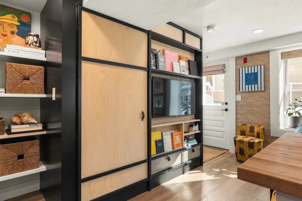 Функциональная, яркая и уютная – именно так описывают своё жильё хозяева. Сложно с этим поспорить, особенно когда на фоне гармоничного разнообразия оттенков ты видишь «домашний кинотеатр», который прячем за собой стиральную машинку и сушилку. 