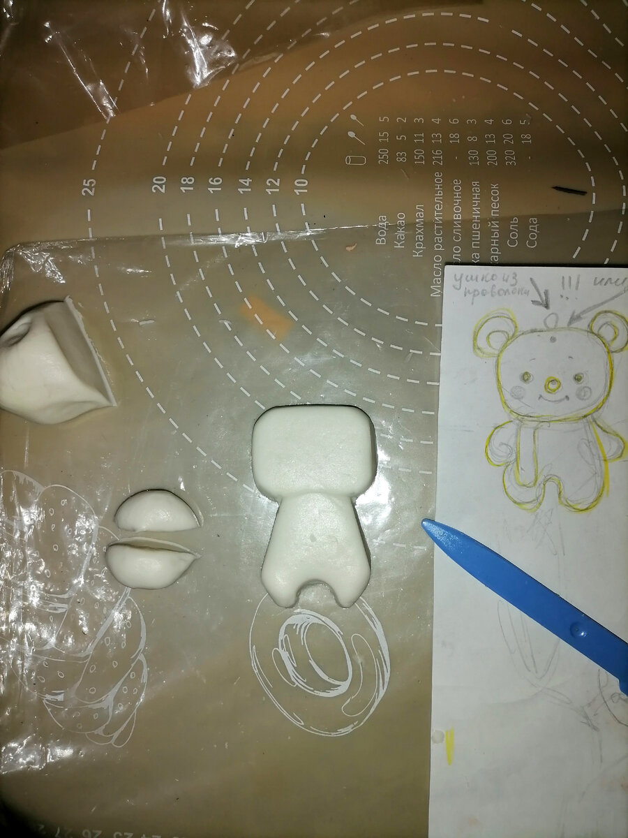 пластмассовым ножиком для пластилина обрезала с краёв до нужных очертаний тельца мишки.То-же проделала с головой. 