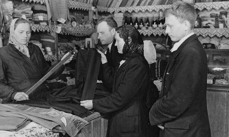 Деревенская семья выбирает в сельмаге материал для пошива. Фото из открытых источников. 