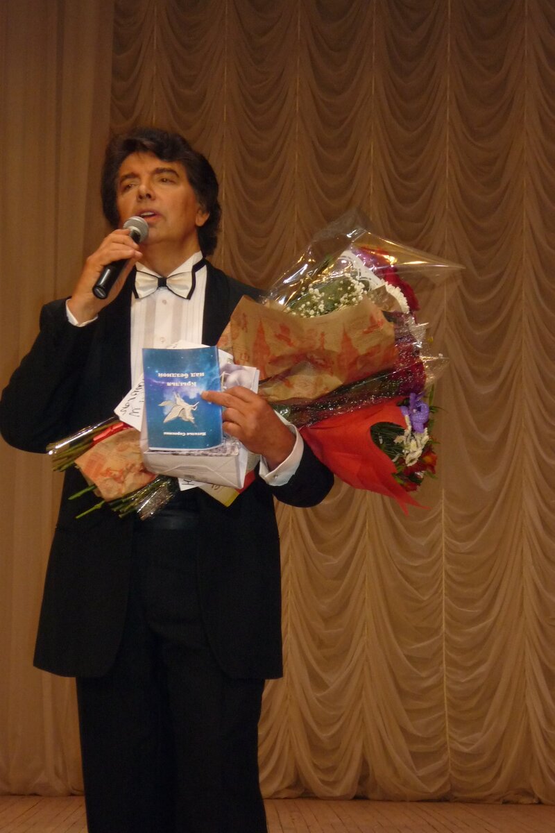 Сергей Захаров держит в руках сборник стихов Натальи Сорокиной "Крылья над бездной", включающий стихи, посвященные ему Натальей Сорокиной 