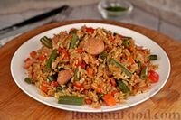 Обжаривание отварного риса с разными добавками очень популярно в азиатской кухне. В этот раз для сочности используем морковь, сладкий перец и стручковую фасоль, а в качестве мясной составляющей подойдут сосиски. Соевый соус и яйца свяжут ингредиенты и придадут завершённость блюду.