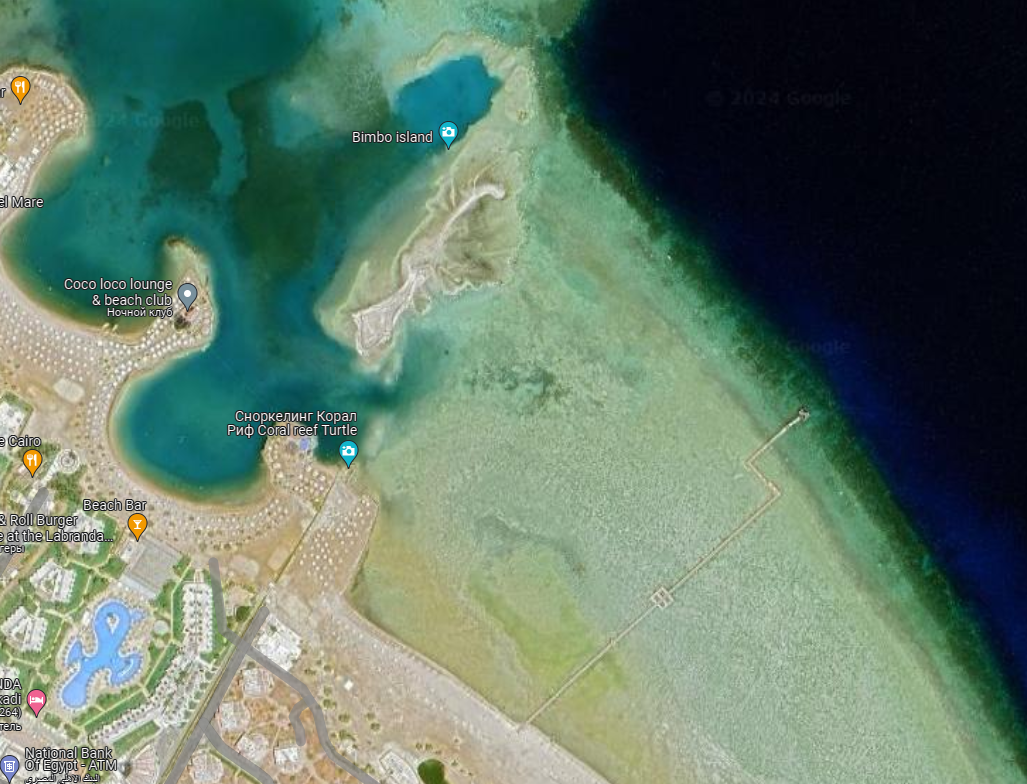 Крупнее. Видна полукруглая лагуна пляжа Клаба, островок и пирс соседнего отеля.