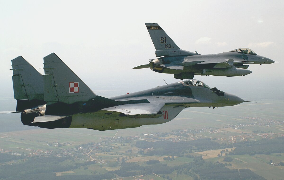    OVER KRZESINY AIR BASE, Poland -- An F-16 Fighting Falcon flies in formation with a MiG-29 here during exercise Sentry White Falcon 05. The F-16 is assigned to the Illinois Air National Guard's 183d Fighter Wing in Springfield. (U.S. Air Force photo by Tech. Sgt. Shaun Kerr) editor