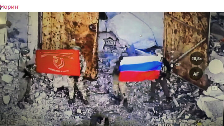 ПЕРВАЯ СЛАВЯНСКАЯ БРИГАДА ВОДРУЖАЕТ ЗНАМЁНА НАД ВОИНСКОЙ ЧАСТИ БАЗЫ ПВО У АВДЕЕВКИ. СКРИНШОТ КАДРА ВИДЕО ТГ-КАНАЛА "НОРИН"