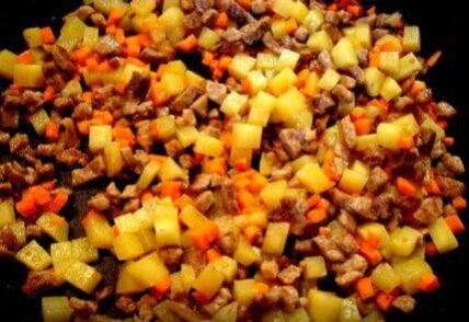Обжарить мясо на оливковом масле в течении 5 мин. Добавить также порезанные мелкими кубиками картофель и морковь. Обжарить еще минут 5.
