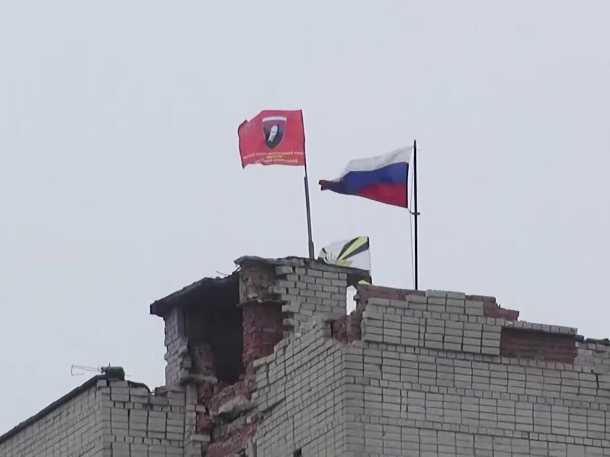    Российский флаг на здании, пострадавшем в результате обстрелов в Авдеевке© РИА Новости