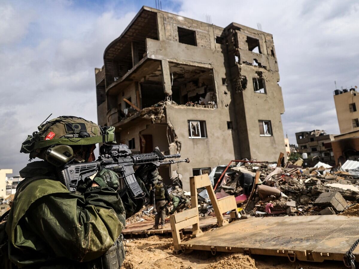Израильский солдат перед разрушенным зданием в Хан-Юнисе© AFP 2024 / NICOLAS GARCIA