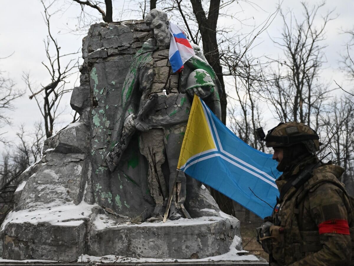   Военнослужащий Центрального военного округа возле памятника в городском парке на территории освобожденной Авдеевки© РИА Новости / Станислав Красильников