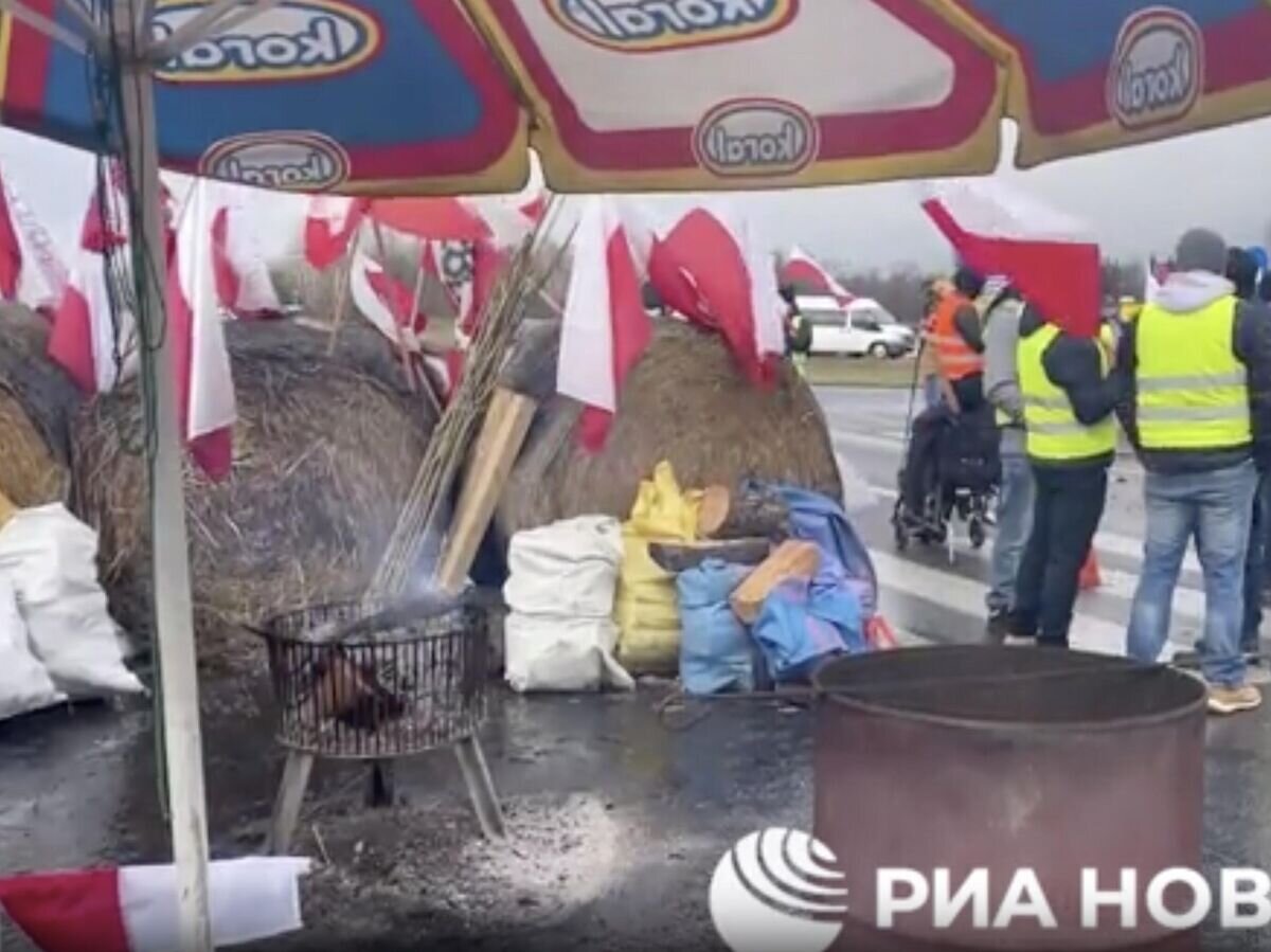    Протестующие польские фермеры перегораживают дорогу на границе с Украиной. Кадр видео© РИА Новости