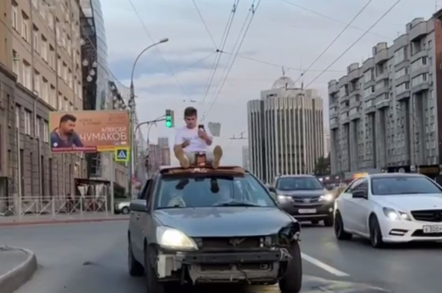    Парень проехался на крыше автомобиля Mitsubishi. Фото: Telegram-канал «Новосибирский паблик»