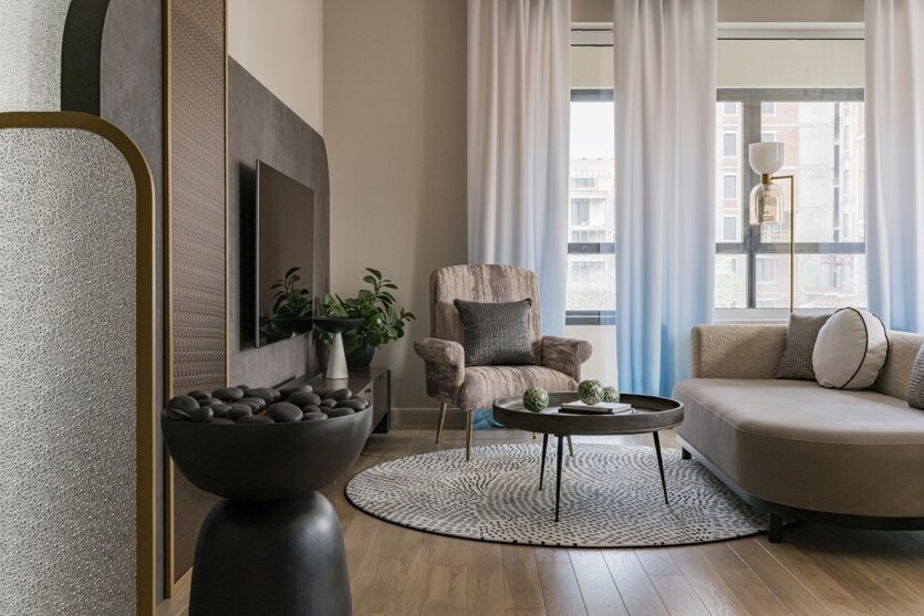 Большой диван («Лори Мебель») в зоне отдыха имеет плавные формы, а сочетание гладкой и фактурной ткани добавляют ему приятной тактильности. Кресло с обивкой, словно полотно художника, ковер с мелким орнаментом, стеклянные перегородки с рельефным стеклом — все это наполняет интерьер выразительностью и глубиной. Кресло, Tamamm. Подвесная тумба (МДФ, тонированное стекло, «БИС-интерьер». Ковер, «Ами Ковры». Журнальный столик, OneAndHome. Около ТВ — ваза, Uttermost. На диване — декоративные подушки CHIA, компания «Текстильные решения Ирины Чертихиной». Торшер, Центрсвет.