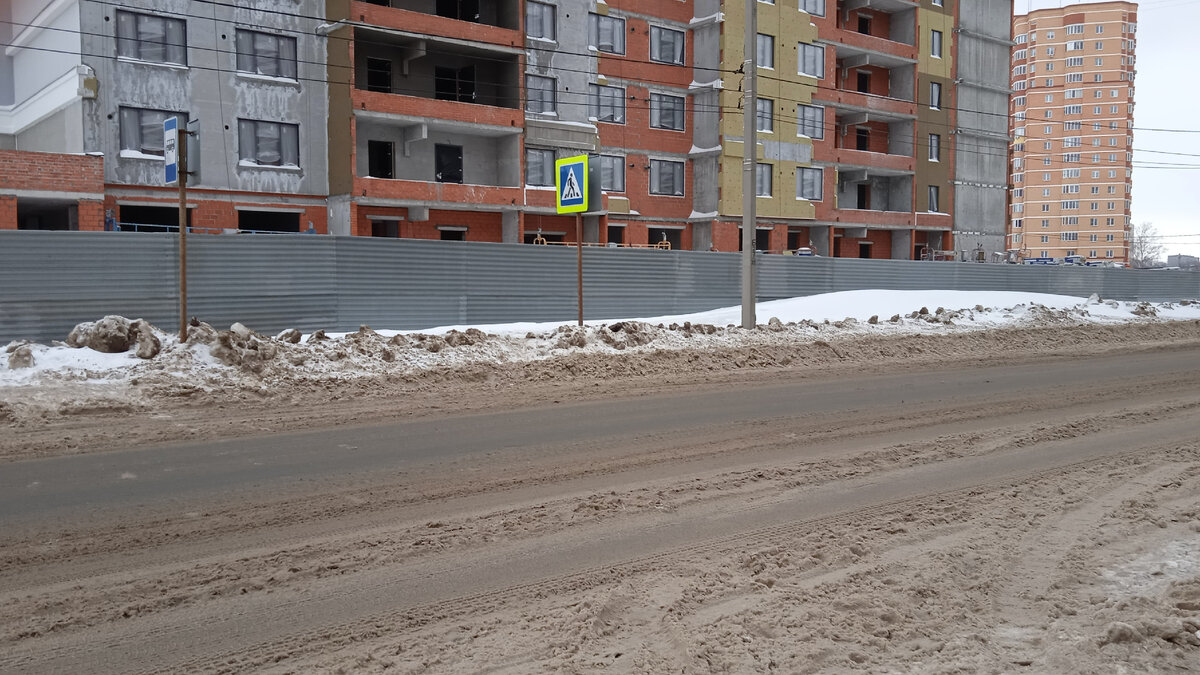 Остановка и переход напротив Налоговой Вдоль забора тротуар расположен.