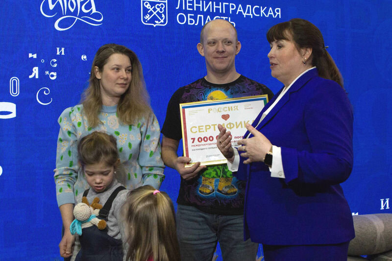    Семье вручён сертификат на шестидневный тур (фото: представительство губернатора и правительства Ленинградской области при Правительстве РФ)