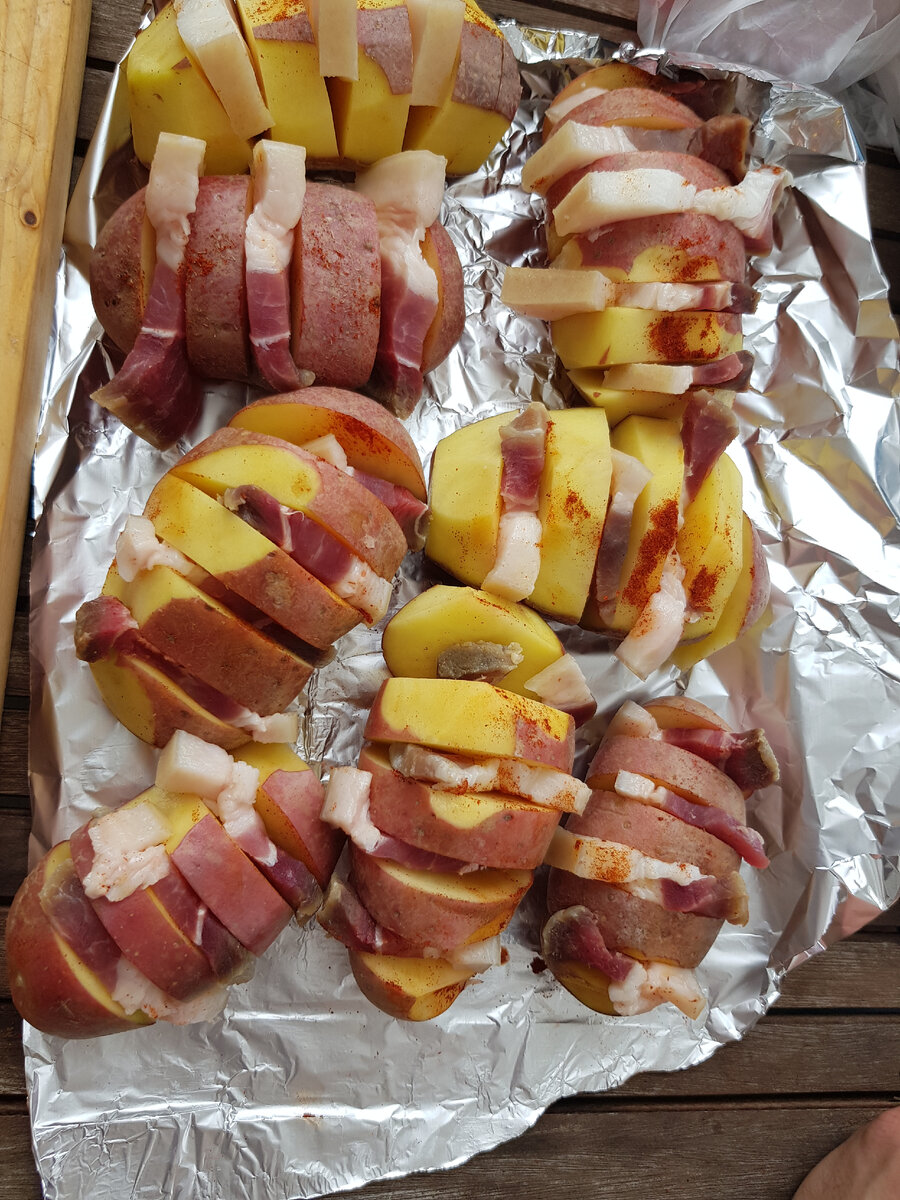 Картошечку надрезать не до конца, в образовавшиеся прорези посыпать приправу с солью. Я использую "подравку". Вложить кусочки сала и сверху присыпать толикой парики. Завернуть в фольгу и запекать в духовке до готовности картошки.😃