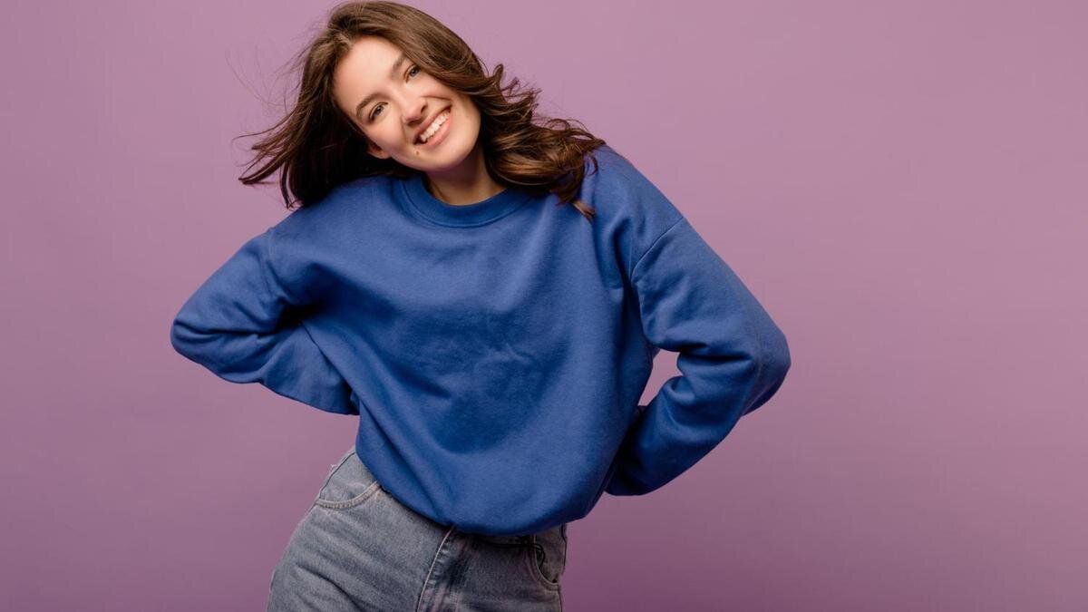    Девушка в синем свитшоте и светлых джинсах:Freepik/lookstudio