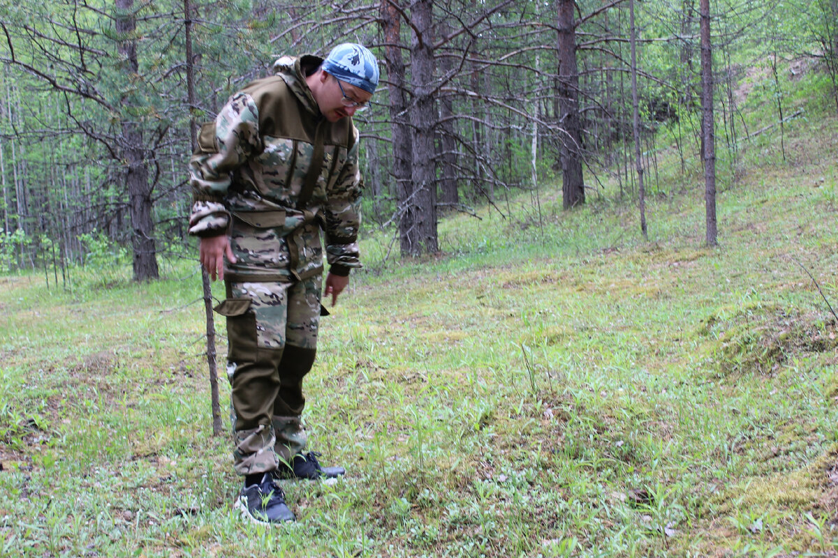 Константин Полунин исследует могилу в лесу поселка Изъяю