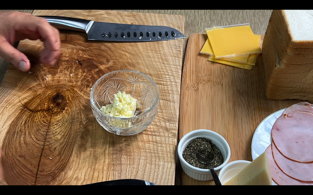 Для начала нам понадобится взять 3 зубчика чеснока и мелко нарезать, как на фото. Далее берем 30г  сливочнонго масла (оно должно быть мягким) и высыпаем к нему нарезаный чеснок и 1 чаную ложку сушенного базилика, все тчательно перемешиваем и пока убираем в сторону.