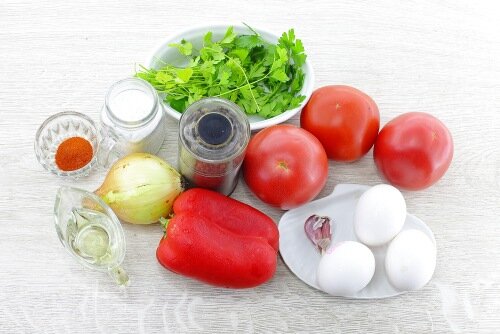 Шаг 1 Подготовить необходимые ингредиенты для шакшуки на сковороде.Чтобы шакшука получилась вкусной, нужно выбрать свежие яйца. При покупке яиц обратить внимание на внешний вид. Поверхность скорлупы должна быть слегка шершавой. Если она гладкая и блестящая, это говорит о том, что яйца залежались.На скорлупе не должно быть пятен и механических повреждений. Если яйцо покрутить на поверхности, и оно хорошо крутится, значит, продукт испорченный. Свежие яйца не крутятся. Если яйцо опустить в подсоленный раствор, свежие яйца остаются на дне.Непосредственно перед употреблением яйца хорошо вымыть с мылом под струей холодной воды и обсушить бумажной салфеткой.Вкус готового блюда напрямую зависит от выбора качественных овощей. Помидоры покупайте вкусные, спелые, без механических повреждений, пятен и признаков порчи. Сорт и цвет может быть любым. Я предпочитаю более мясистые сорта. Плоды, которые потяжелее, содержат больше мякоти. У помидоров должен быть приятный насыщенный помидорный аромат.Болгарский перец лучше всего использовать мясистых сортов. А чтобы шакшука получилась более яркой, можно взять перец разного цвета.Из зелени я использовала петрушку. Она отлично гармонирует со овощами и яйцами. В данном рецепте можно использовать любую зелень на ваш вкус: кинзу, базилик, укроп, сельдерей.