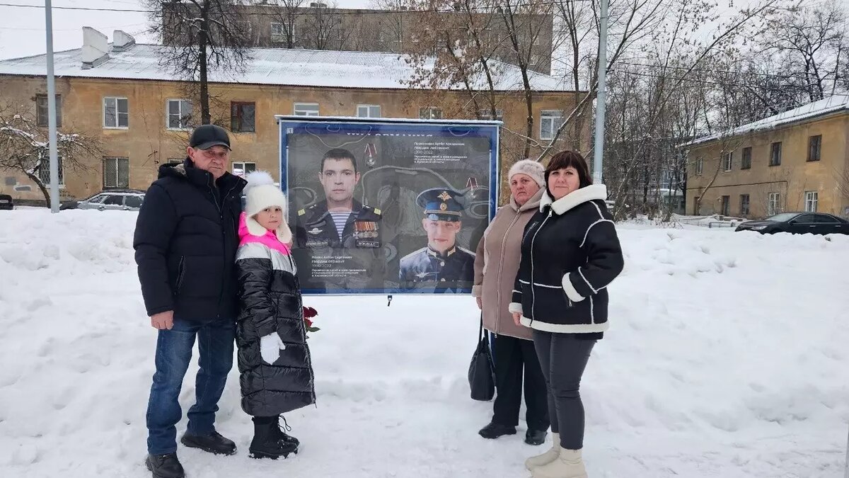 Олеся Мокина с дочкой и родителями у портрета мужа. Фото: rzn.info