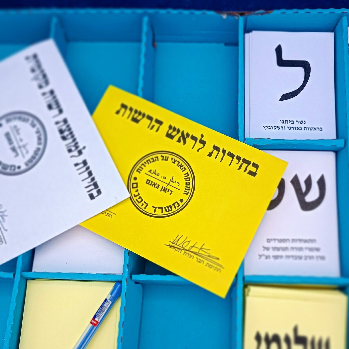 наполнение кабинки для голосования. Белый конверт за партийные списки, желтый конверт за мэра