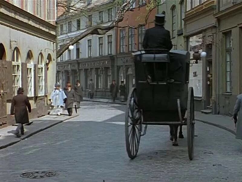 В кадре то и дело проезжают черные кареты с мужчинами в цилиндрах с уздами 