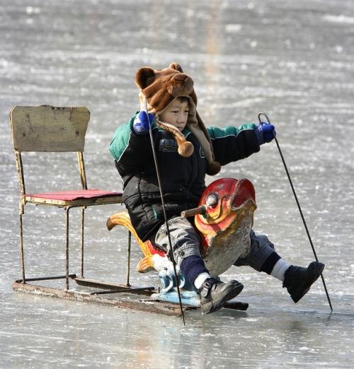Китайский мальчик на специальных ледовых санках