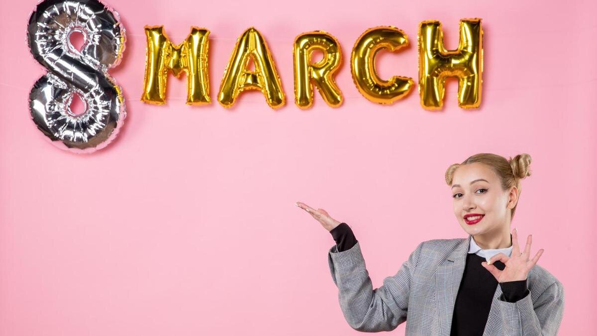    Девушка указывает на надпись 8 Марта:Freepik