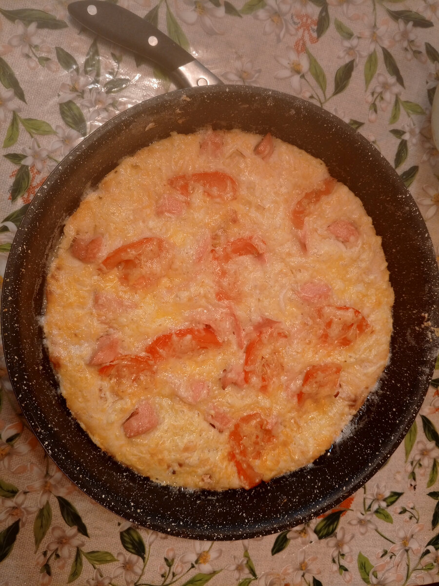 Пицца. Там сыр, лук, колбаса и помидоры, тесто на сметане