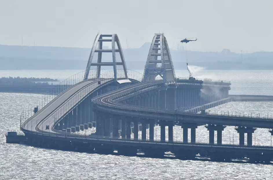 Вертолёт сбрасывает воду для тушения пожара на Крымском мосту, который соединяет материковую часть России и Крымский полуостров через Керченский пролив © Uncredited/AP/dpa