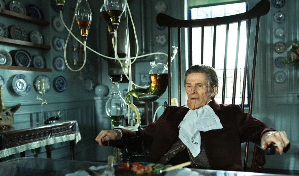 Годвин Бакстер (Уиллем Дефо) из-за неспособности организма вырабатывать желудочный сок, вынужден во время каждого приема пищи подключать к себе специальный аппарат