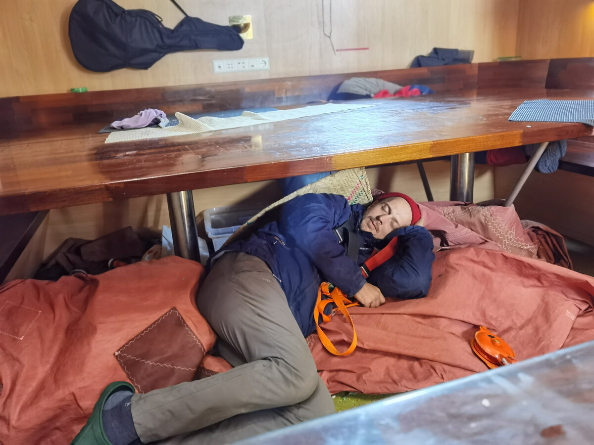 Матрос спит в стакселе перед выходом на палубу