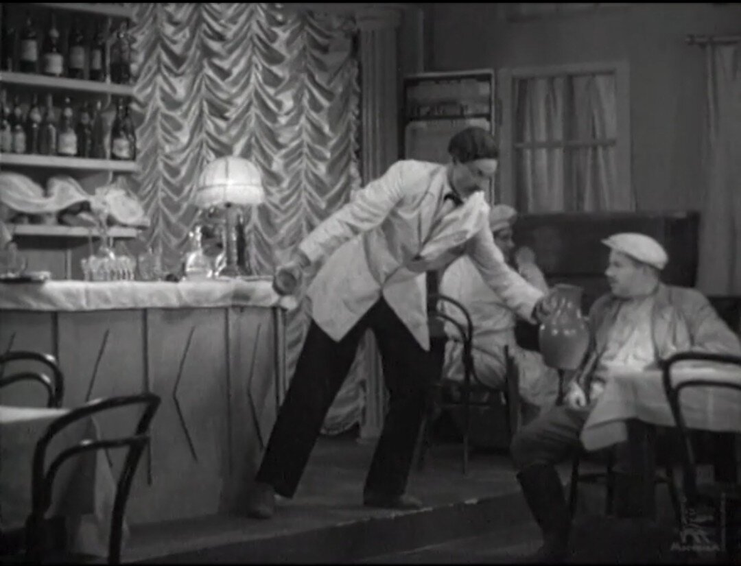 Персонаж фильма "Волга-Волга" (1938) в кафе провинциального городка Мелководск. Скриншот кадра из фильма 