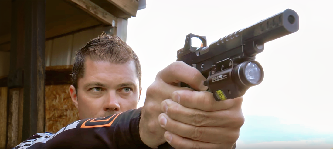 Стрелок держит пистолет правой рукой и целится правым глазом.