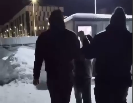 Совсем не инновационный строительный вагончик в "городе будущего". В центре – хрупкий и малорослый иностранный специалист, обвиняемый в изнасиловании малолетней. Скриншот видео ТГ-канала "Многонационал"