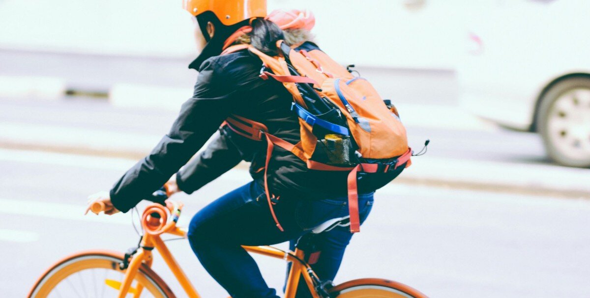 Курьерский работник на велосипеде.