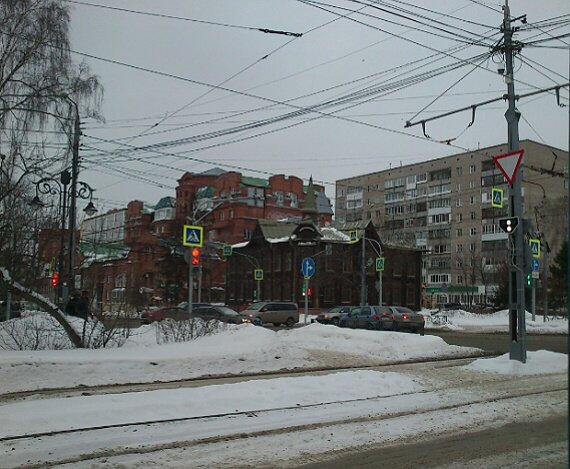 Отреставрированное здание деревянного зодчества в центре Томска. Жду свой трамвай на остановке